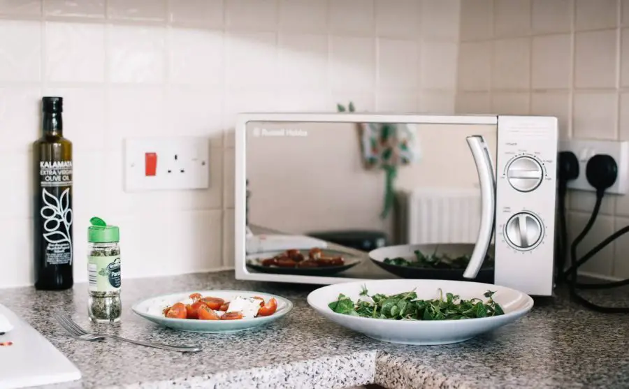 two white ceramic plates near microwave on counter to