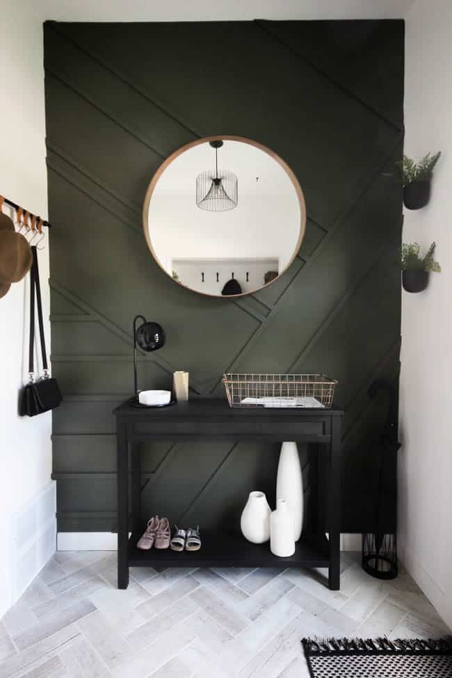 Beautiful entryway with green wall and herringbone tile