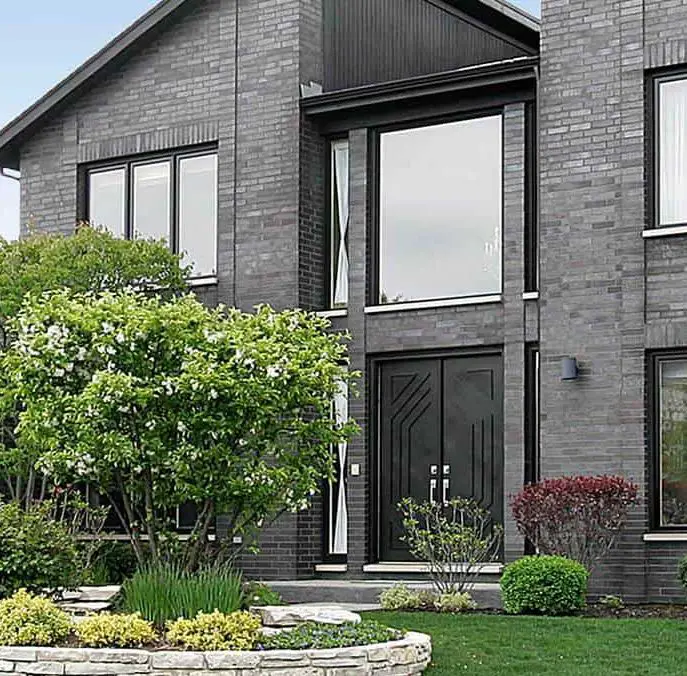 Modern home with gray brick and black door