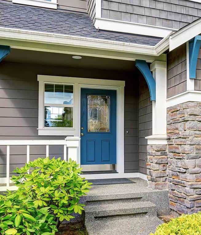 Modern house with grey exterior white trim and blue door
