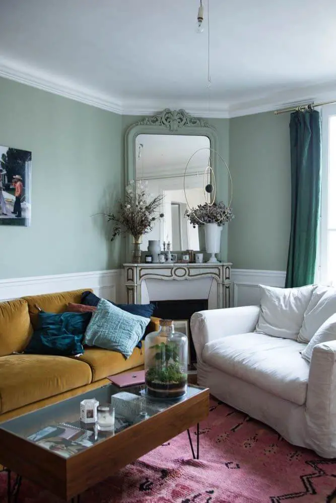 Parisian living room with green walls and mustard yellow sofa