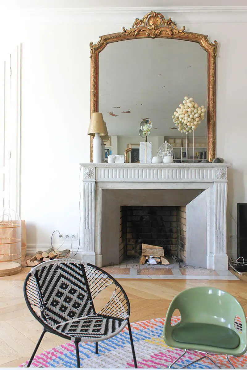 Parisian living room with modern accent chairs and marble fireplace