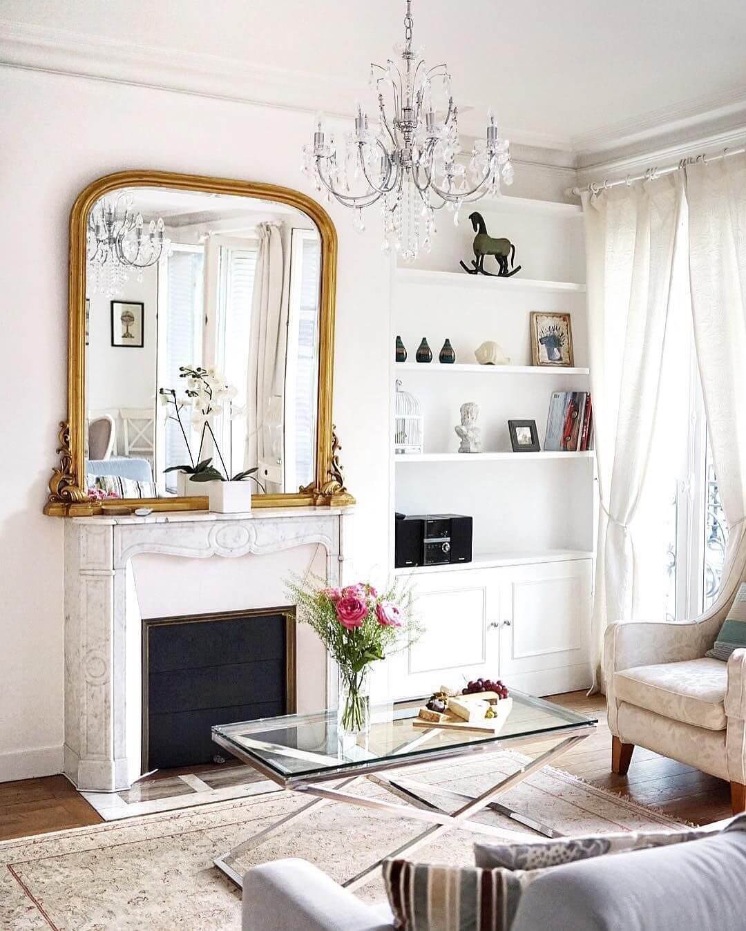 Parisian living room with gold mirror and glass coffee table