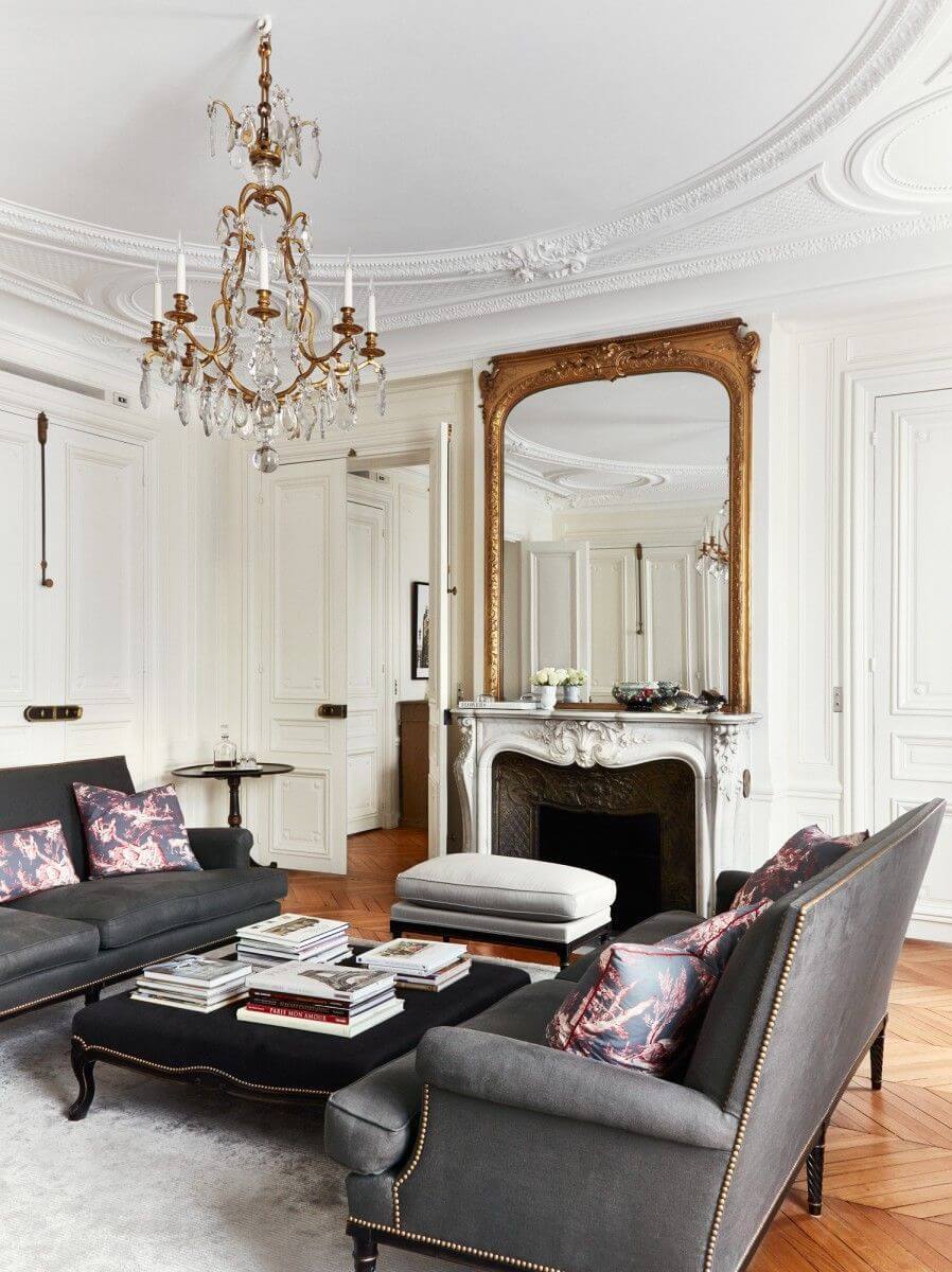 Parisian living room with crystal chandelier and ottoman as coffee table