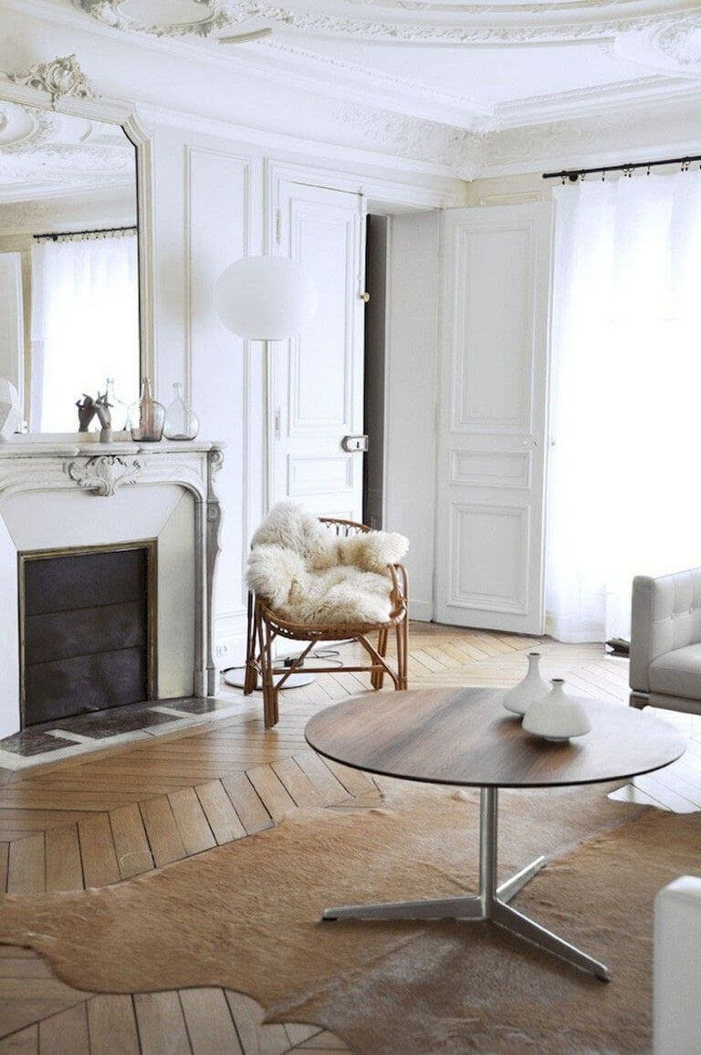 Parisian living room with cowhide rug rattan chair and brown round coffee table