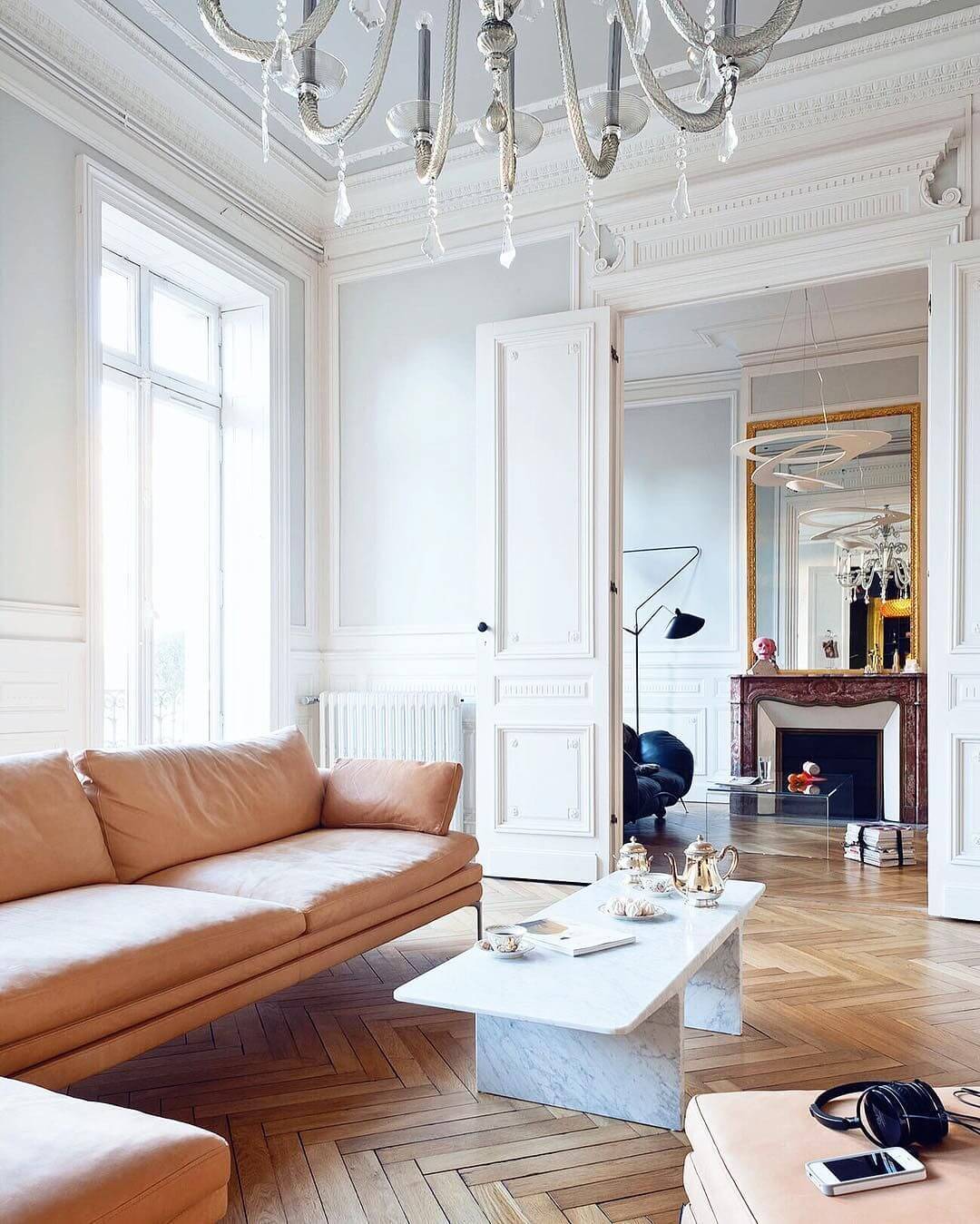 Parisian living room with beige sofa and white marble coffee table