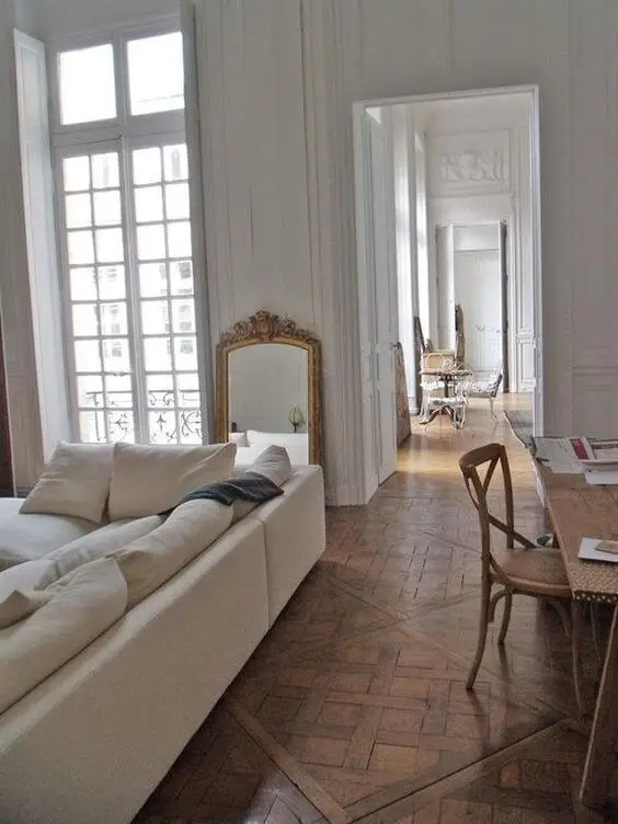 Parisian living room decor with beige sofa and leaning wall mirror