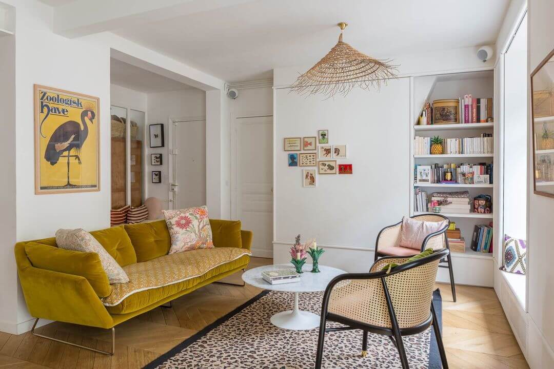 Parisian living room with mustard yellow sofa and cane accent chairs