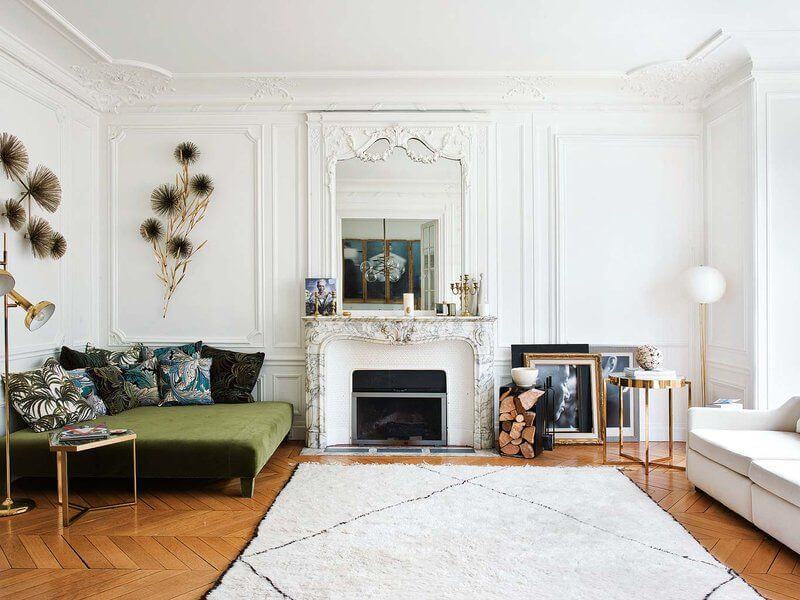 Parisian living room with marble fireplace and green velvet ottoman