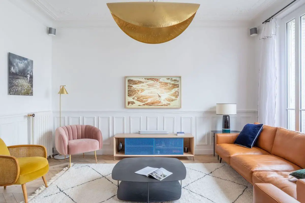  Parisian living room with brown leather sofa pink and yellow accent chairs