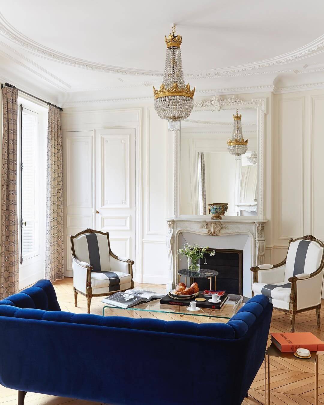 Parisian-living-room-with-blue-velvet-sofa-and-crystal-chandelier