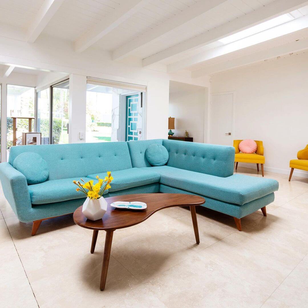Mid Century Modern Living Room with Turquoise Sectional Sofa and Curving Wood Coffee Table