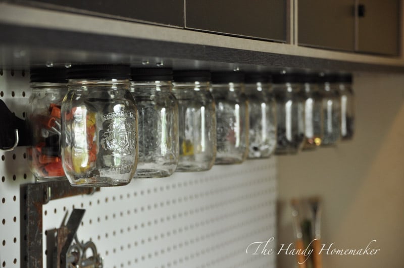 Mounted storage beneath a shed cabinet using mason jars with lids. 
