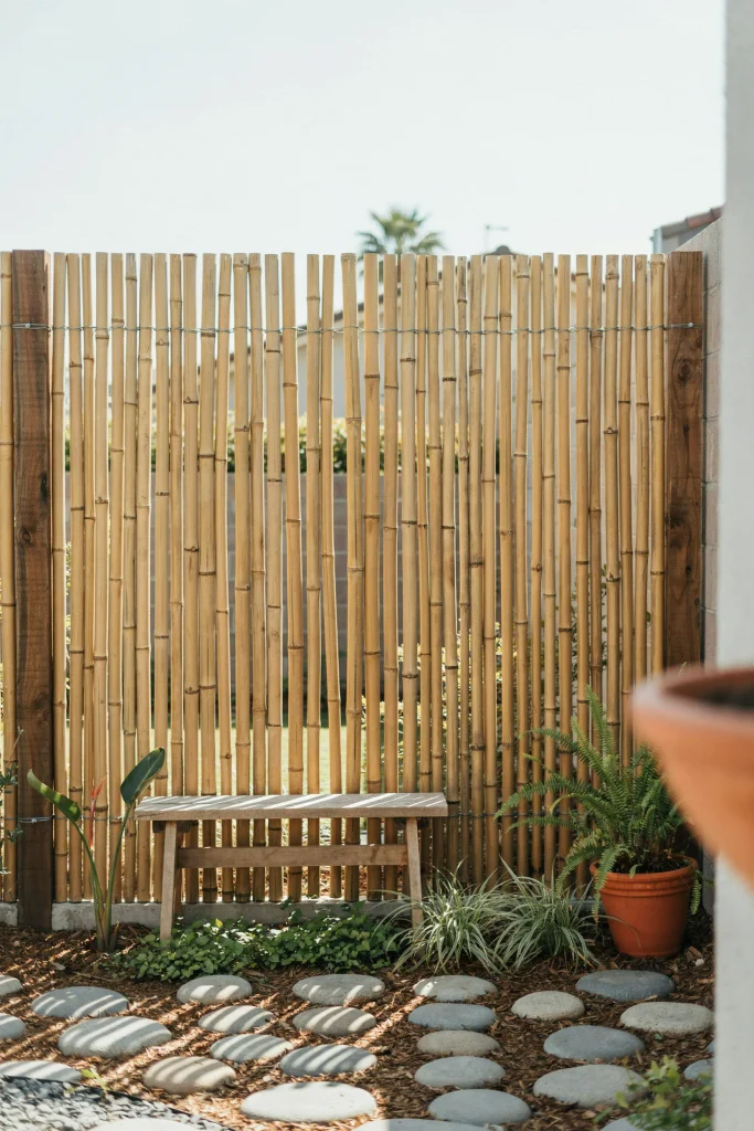 Natural bamboo privacy fences beautifully paired with pavers along fence line